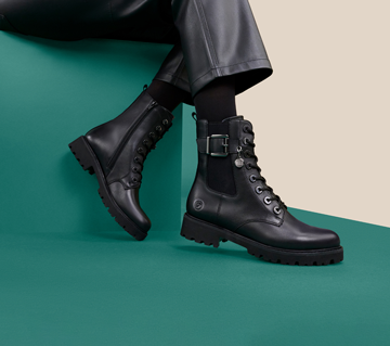 Remonte black combat boot on green background
